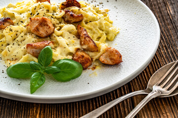 Classic creamy chicken alfredo fettuccine pasta on wooden table