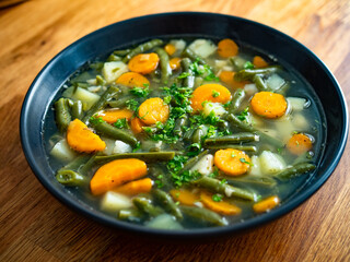 Green bean soup on wooden table	