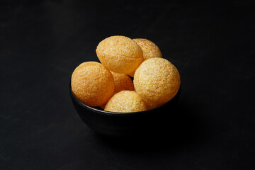 Delicious north and south indian street food pani puri gol gappa with tamarind water served in black bowl