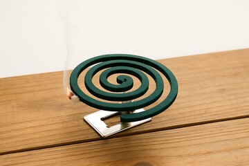 Burning mosquito coils on wooden ground on white