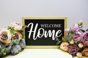 Welcome Home text message with flowers bouquet decoration on purple background