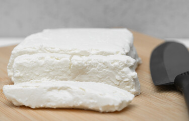 White cottage cheese, crumbly, cut into pieces, close-up, macro, calcium-rich dairy product