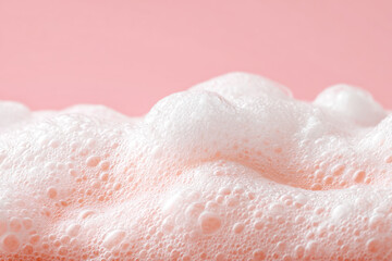 Fototapeta premium Close-up of pink bubbly foam on a pastel background