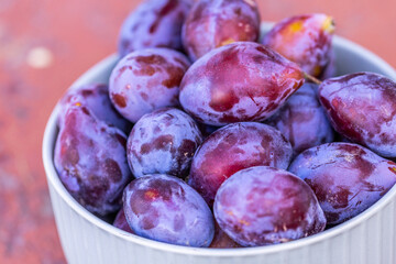 Fresh Plums in a White Bowl Close-up View