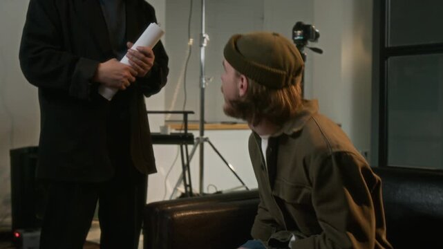 Tilt-up shot of filming director informing anxious actor of passing audition and approving him for role