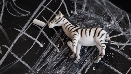 Zebra toy on chalkboard with chaotic chalk drawings