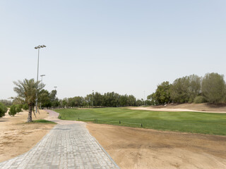 Manicured fairways and palm-lined greens of Abu Dhabi Golf Club on a bright, sunny day, showcasing...