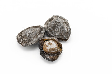 Close-up of salted apricot kernels at shell roasted in ash isolated on white background. Shurdanak or Donakshurak is a popular treat of Uzbek and Tajik cuisines