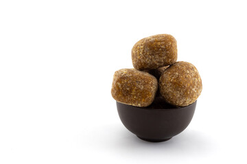 Balls of traditional Altai dessert Tok Chok or Chok-Chok in brown bowl isolated on white background. Tok Chok made from talkan and honey. Talkan is coarse flour made from roasted barley or wheat