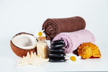 Rolled terry towels, shell, pyramid of stones, coconut, starfish, chamomile flowers. Light...