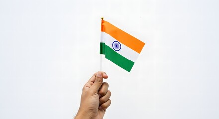 A hand proudly holds a small Indian flag against a plain white backdrop.