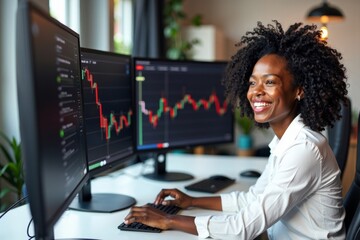 Black woman sitting at home trading stocks online while monitoring multiple computer screens, smiling.