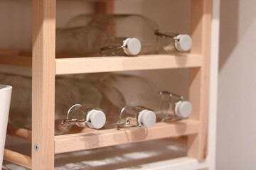 Glass Bottles on Wooden Shelf in Modern Kitchen