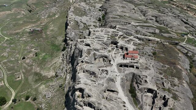 A 4K drone view of Uplistsikhe Cave City in Georgia. This video captures the ancient rock-hewn town overlooking the Mtkvari River, highlighting its historical architecture and unique landscape.