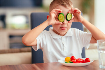 Creative boy playing with vegetables while eating