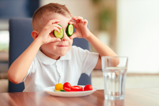 Creative boy playing with vegetables while eating