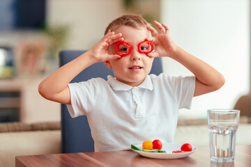 Creative boy playing with vegetables while eating