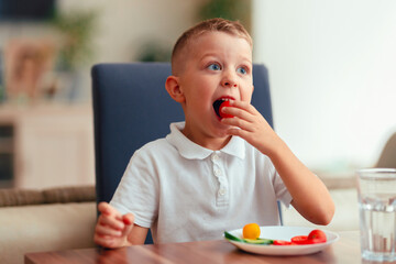Creative boy playing with vegetables while eating