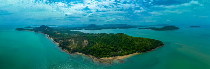 A breathtaking aerial view of a lush green coastline with winding paths, crystal-clear turquoise...