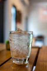 A clear glass filled with ice cubes and water. Refreshing glass of water