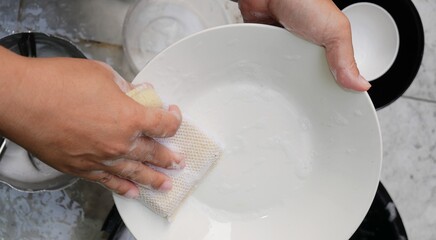 hands of a woman washing dishes