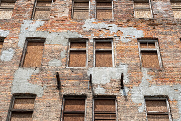 Abandoned Brick Building with Boarded Windows and Peeling Plaster