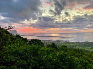 Blick aus dem tropischen Urwald in den Bergen von Mauritius auf das Meer bei Sonnenuntergang