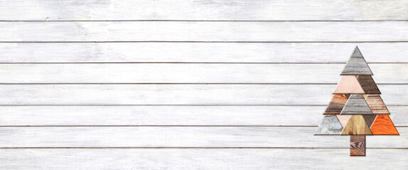 Eco friendly Christmas background. Homemade Christmas tree made of natural biodegradable wooden boards of different color. Ecology, environmental conservation, zero waste concept. Copy space for text