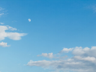 The moon is shining brightly in the sky, casting a silvery glow over the blue expanse. It is...