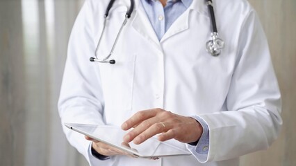 Doctor man with stethoscope using tablet computer in hospital. Medicine and science concepts