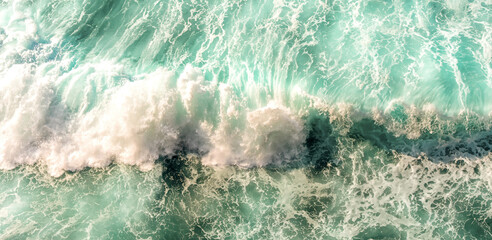 Aerial turquoise ocean wave with foamy surf