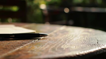 Elegant pen resting on an open notebook, inviting you to capture your thoughts in this peaceful outdoor setting in the golden afternoon sun
