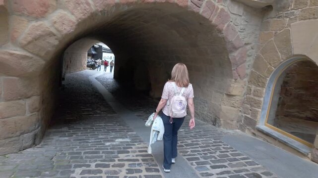 Tourist woman walking through the medieval historic center of the town of Getaria in northern Spain.