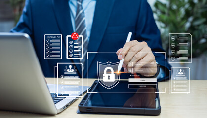 Businessman working on laptop at home with virtual screen displaying icons for cybersecurity,...
