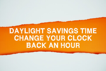 Daylight Saving Time text on orange with white paper torn ripped of horizontal