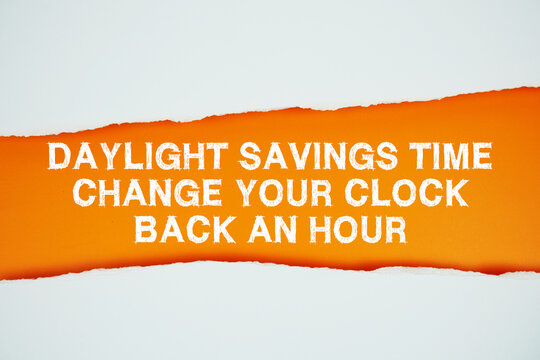 Daylight Saving Time text on orange with white paper torn ripped of horizontal