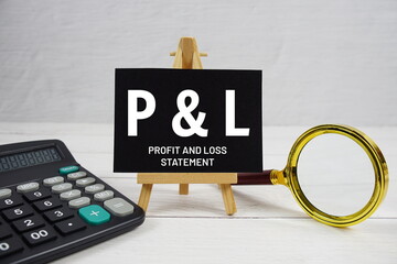 P and L abbreviation of Profit And Loss Statement text with magnifying glass and calculator on...