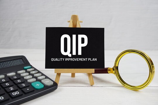 QIP abbreviation of Quality Improvement Plan text with magnifying glass and calculator on wooden background