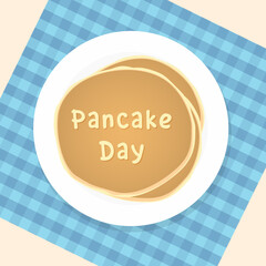 Pancake day. Pancakes on a plate on a tablecloth. View from above.