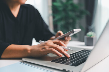 Close-up scene, a female seated at a table holds a smartphone, spending time on modern e-date...