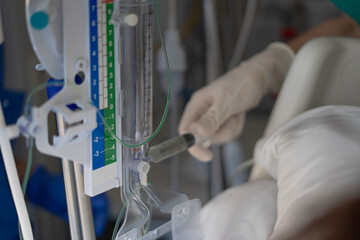 Doctor injecting medicine into iv drip in hospital setting
