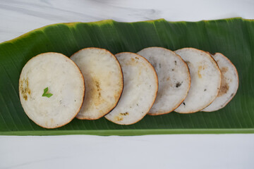 High-angle close-up view of Indonesian serabi cakes served on a banana leaf,