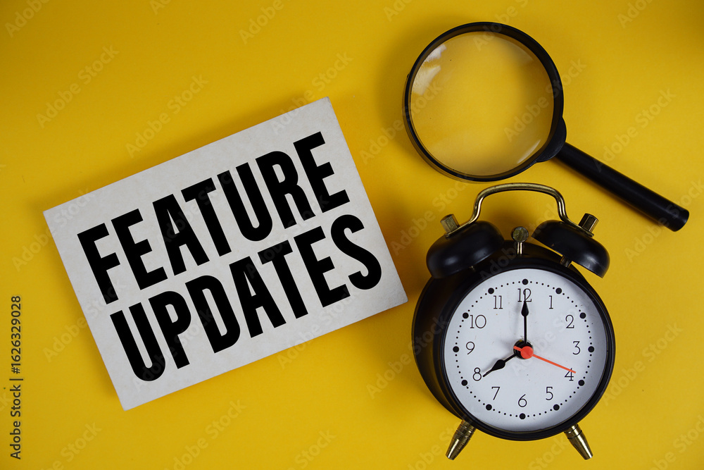 Poster feature updates text written on paper with magnifying glass and alarm clock on yellow background