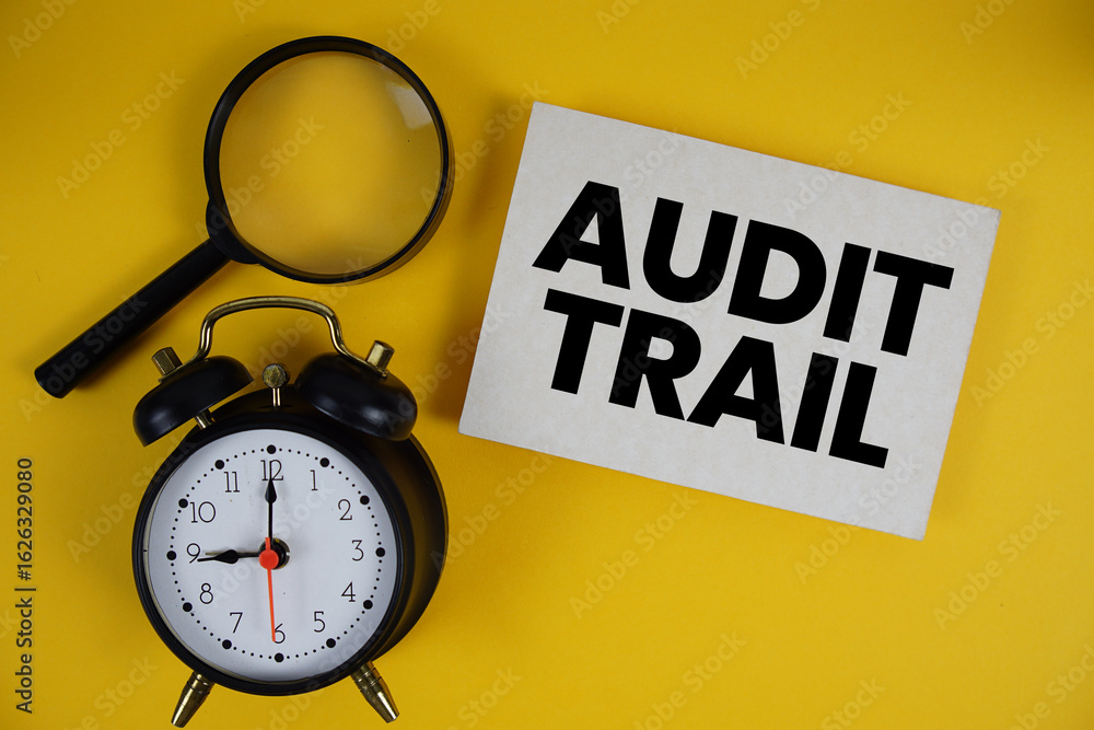 Poster audit trail text written on paper with magnifying glass and alarm clock on yellow background