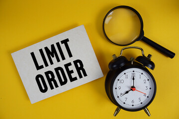 Limit Order text written on paper with magnifying glass and alarm clock on yellow background