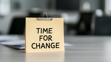 A memo saying "Time For Change" is clipped to a shiny table, implying a need for innovation or transformation in a business or personal setting.