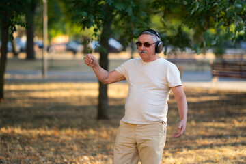 Senior man in headphones outdoors