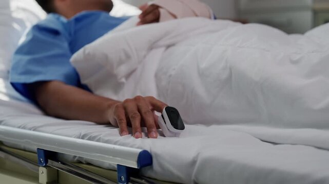 Patient resting in sanitized hospital room, wearing pulse oximeter for monitoring vital signs during medical examination and recovery process
