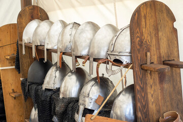 medieval armor helmets on shelf, ready to be used in battle