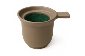 Beige ceramic tea infuser with green plastic filter, standing on transparent surface, enabling precise herbal tea brewing technique